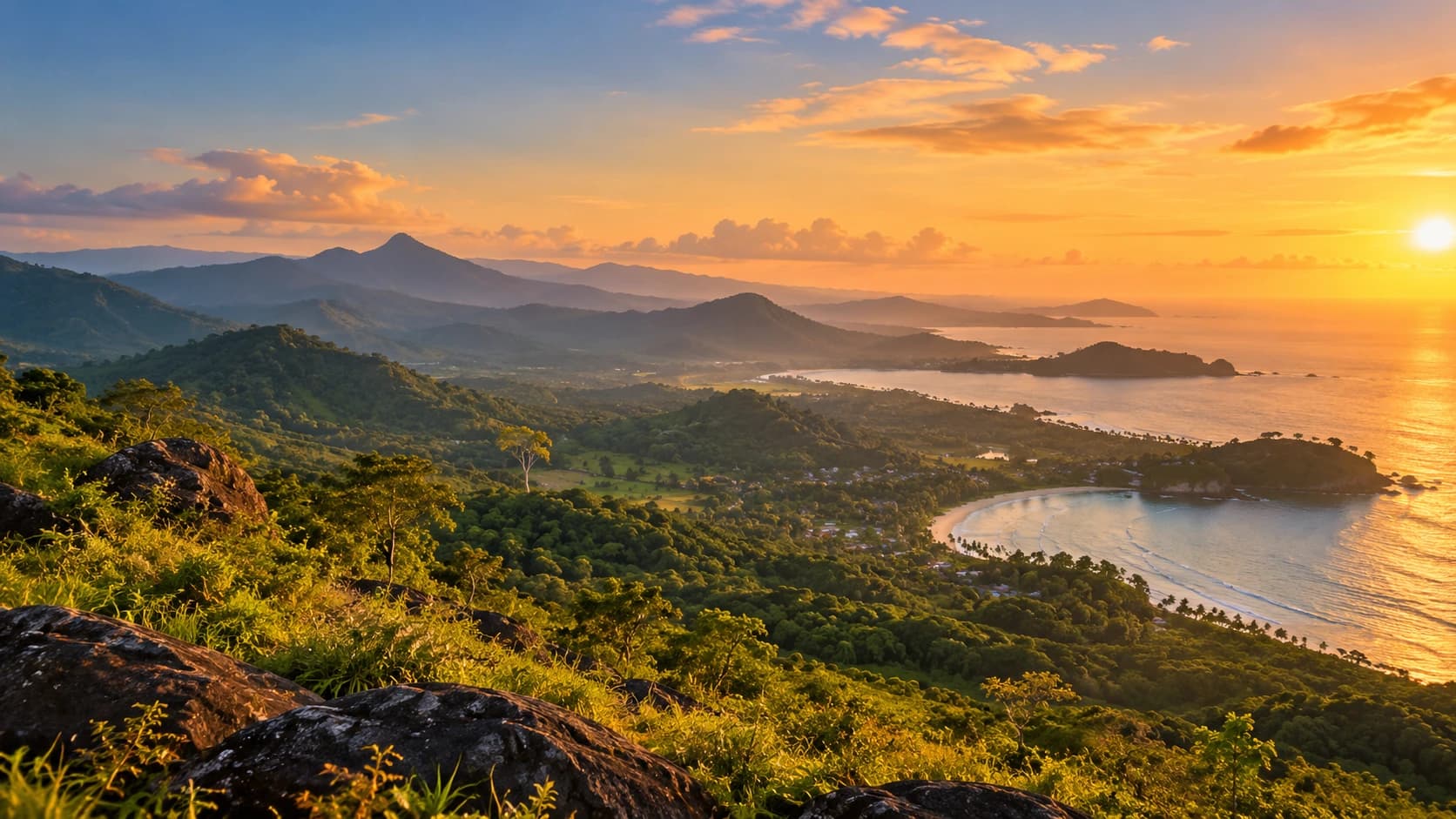 Green hills sloping down to a curved bay and the sea at golden hour